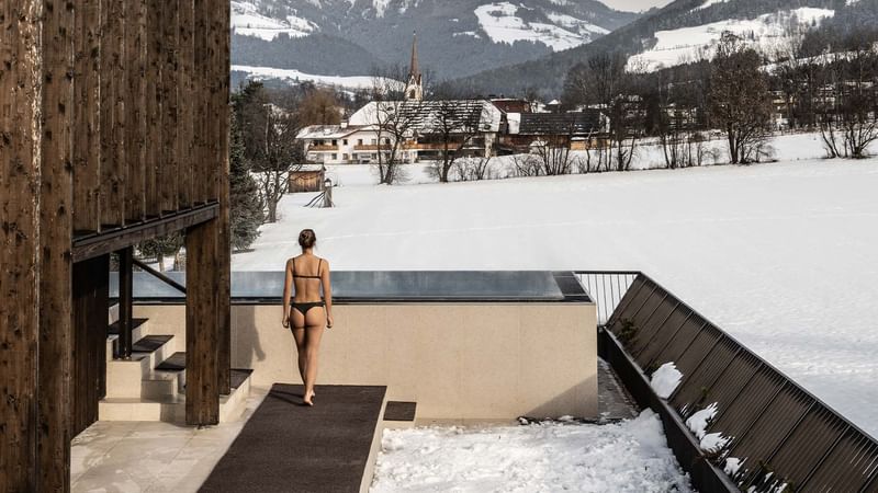 Woman entering an outdoor pool area in a winter setting